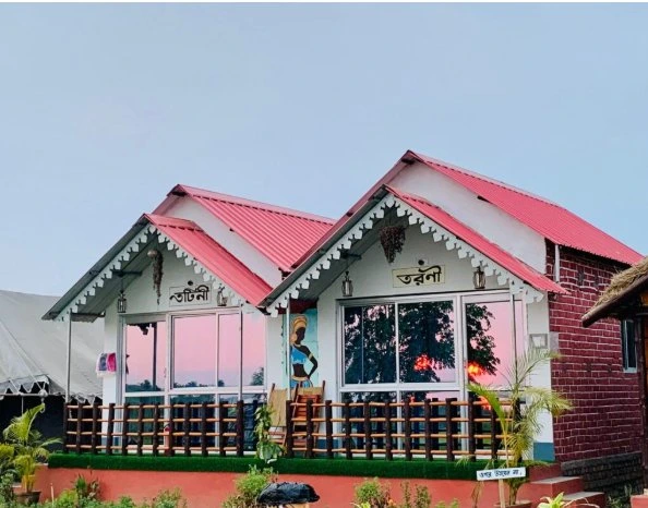 Tarangini Resort cottage exterior with red rooftop at dusk
