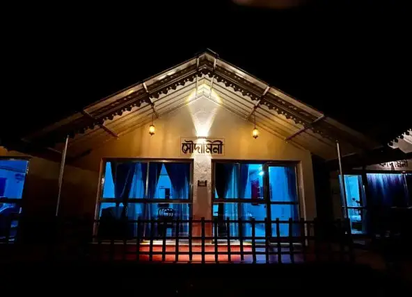 Soudamini cottage lit up at night with warm golden lights