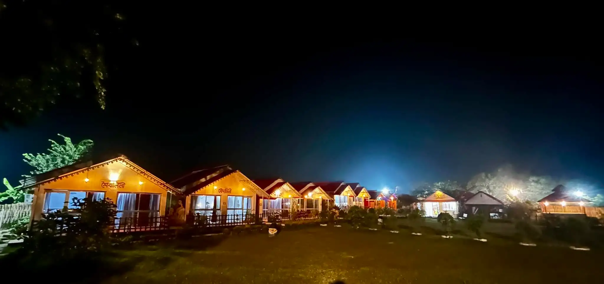 Wide panorama of Tarangini resort glowing under night sky